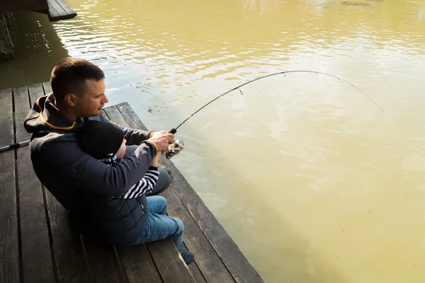 Padre e hijo en el proceso de captura de peces —  Fotos de Stock