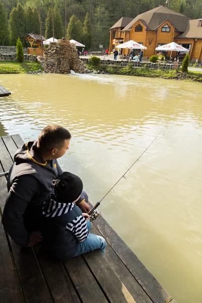 Padre e hijo en el proceso de captura de peces — Foto de Stock