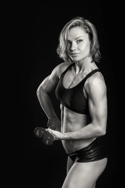 ボディービルダーの女性は彼女の筋肉を示しています — ストック写真