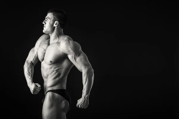 Bodybuilder shows his muscles — Stock Photo, Image