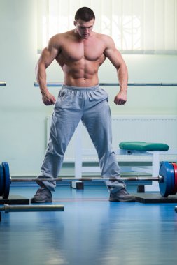 Spor salonunda bir halter alıştırmalar yapan erkek