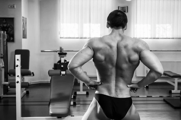 Culturista mostrando i muscoli in palestra — Foto Stock