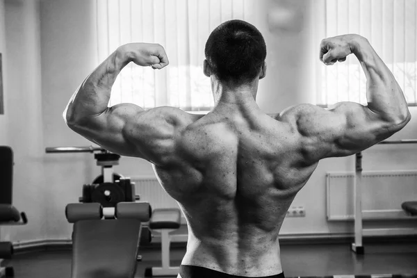 Culturista mostrando i muscoli in palestra — Foto Stock