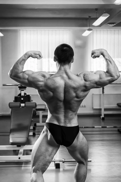 Bodybuilder zijn spieren in de sportschool tonen — Stockfoto