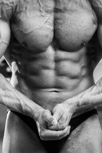 Культурист показывает свои мускулы в спортзале — стоковое фото