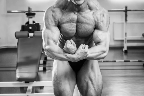 Бодібілдер показує свої м'язи в спортзалі — стокове фото