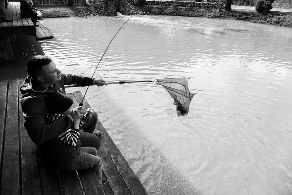 Padre e hijo en el proceso de captura de peces —  Fotos de Stock