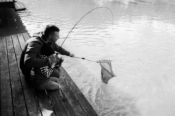Padre e hijo en el proceso de captura de peces — Foto de Stock