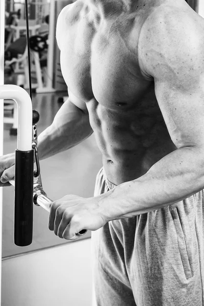 Hombre haciendo ejercicios en el simulador para los músculos . —  Fotos de Stock