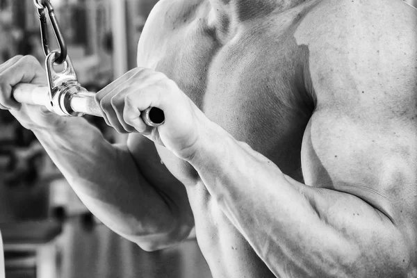 Hombre haciendo ejercicios en el simulador para los músculos . —  Fotos de Stock