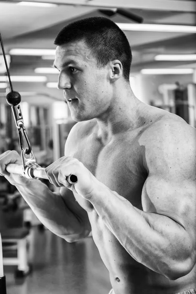 Człowiek robi ćwiczenia na symulatorze na mięśnie. — Zdjęcie stockowe