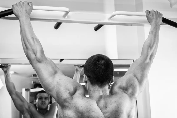 Hombre haciendo ejercicios en el simulador para los músculos . —  Fotos de Stock