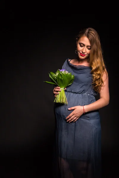 Hermosa mujer embarazada con flores — Foto de Stock