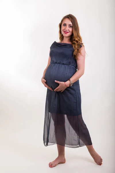 Беременная женщина в сером платье — стоковое фото