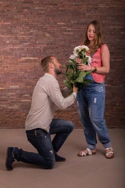 Husband and wife with flowers in the studio — Stock Photo, Image