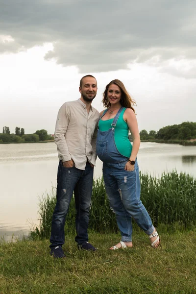 Pareja embarazada en la orilla del lago —  Fotos de Stock