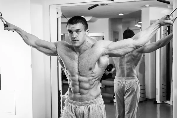 Man doing exercises on the simulator for the muscles — Stock Photo, Image