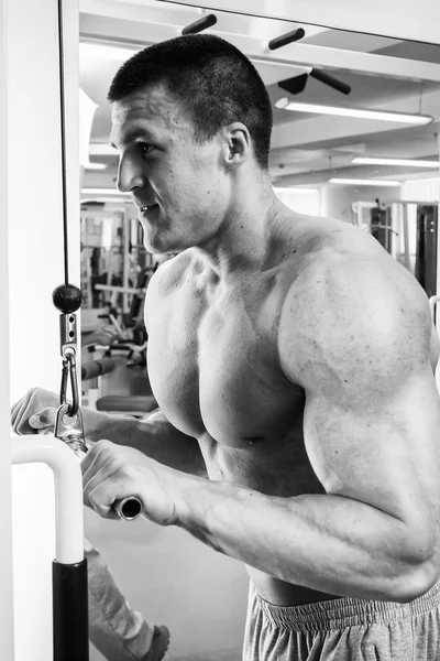 Człowiek robi ćwiczenia na symulatorze na mięśnie — Zdjęcie stockowe