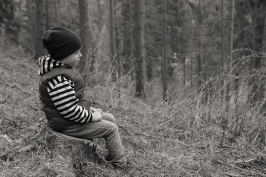 Küçük çocuk ormanda dinleniyor