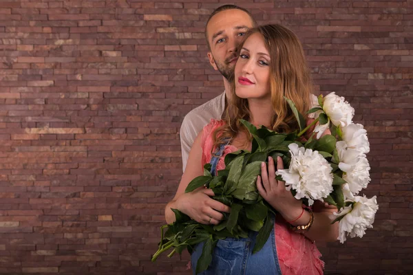 Marido e esposa com flores no estúdio — Fotografia de Stock