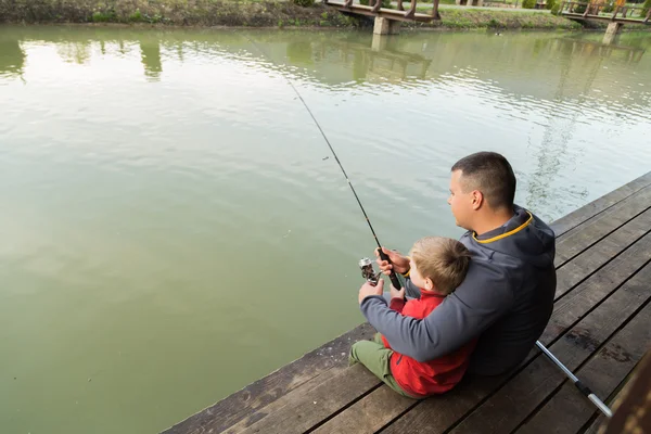 Padre e hijo en el proceso de captura de peces — Foto de Stock