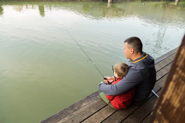 Padre e hijo en el proceso de captura de peces — Foto de Stock