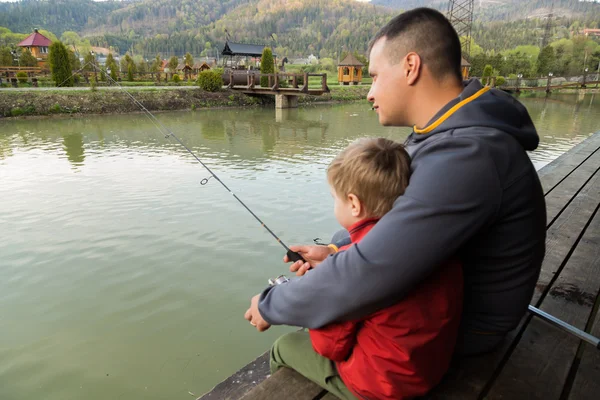 Padre e hijo en el proceso de captura de peces — Foto de Stock