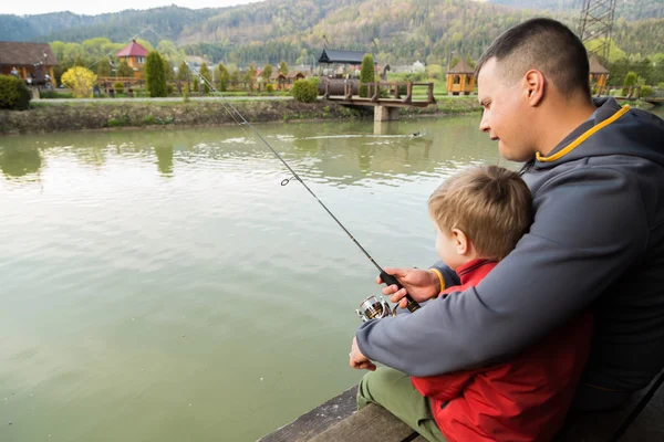 Padre e hijo en el proceso de captura de peces — Foto de Stock