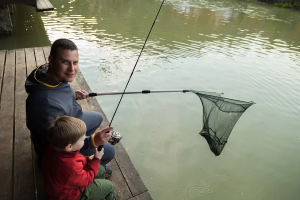 Padre e hijo en el proceso de captura de peces — Foto de Stock