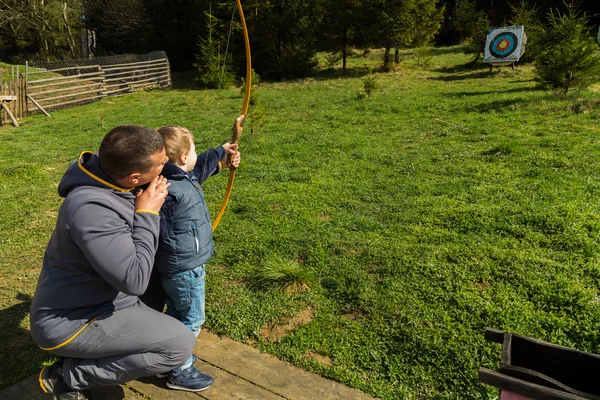 Отец и сын занимались стрельбой из лука — стоковое фото
