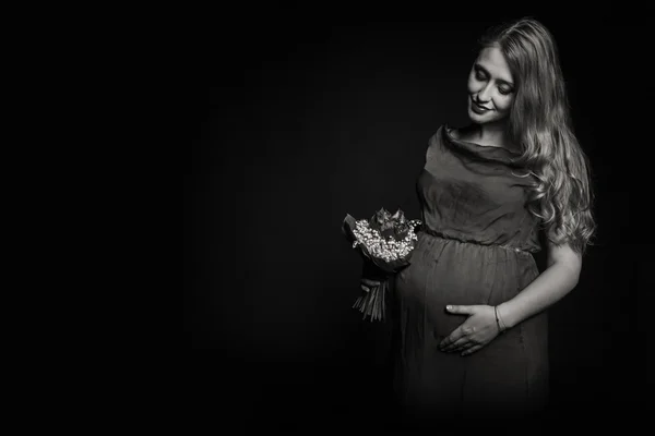 Kobieta w ciąży z bouqet kwiatów — Zdjęcie stockowe