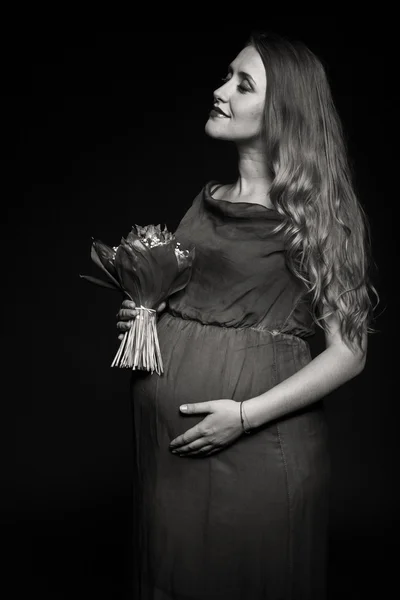 Těhotná žena s bouqet květin — Stock fotografie