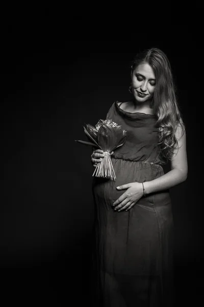 Kobieta w ciąży z bouqet kwiatów — Zdjęcie stockowe