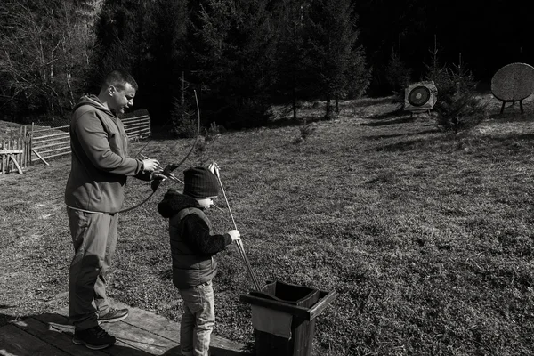 Père et fils engagés dans le tir à l'arc à l'extérieur — Photo