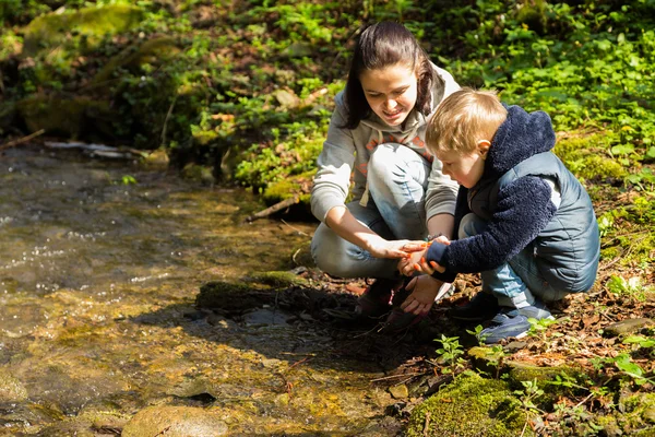 Moeder en zoon in het bos door de rivier — Stockfoto