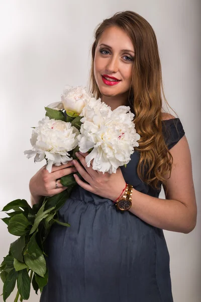 Krásná těhotná žena s květinami — Stock fotografie