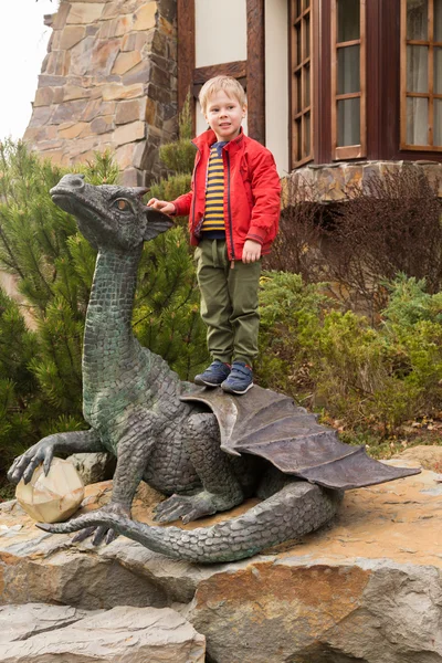 Little boy near the statue of a dragon — Stock Photo, Image