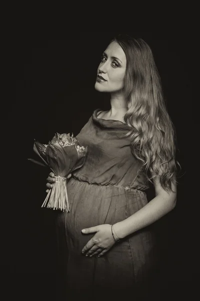 Pregnant woman with bouqet of flowers — Stock Photo, Image