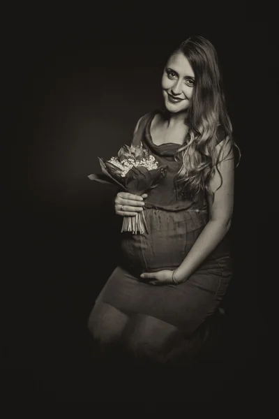 Mulher grávida com buquê de flores — Fotografia de Stock