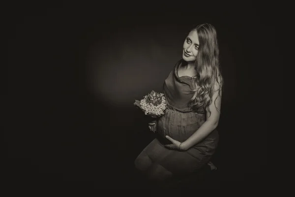 Zwangere vrouw met bouqet van bloemen — Stockfoto