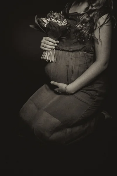 Беременная женщина с букетом цветов — стоковое фото