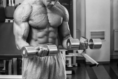 Dambıllarla egzersiz yapan adam.