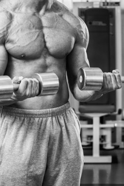 Dambıllarla egzersiz yapan adam.