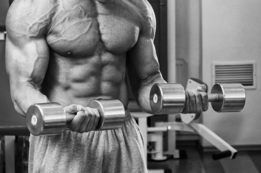 Dambıllarla egzersiz yapan adam.