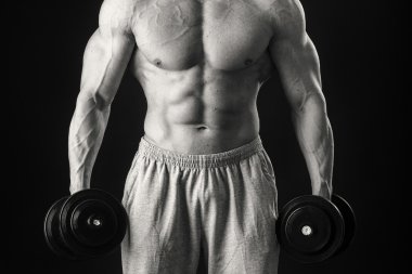 Dambıllarla egzersiz yapan adam.