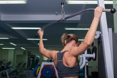Kadın spor salonunda egzersiz yapıyor.