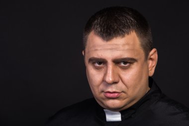 Aktör bir rahip rol oynamaktadır