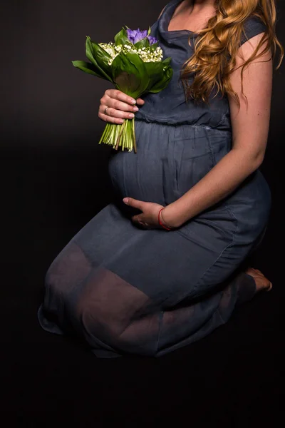 Zwangere vrouw met bouqet van bloemen — Stockfoto