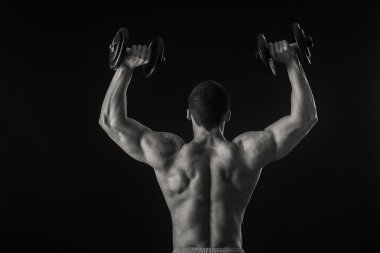 Dambıllarla egzersiz yapan adam.