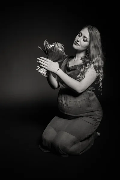 Mujer embarazada con flores — Foto de Stock